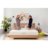 married couple is having a pillow fight on their lazycat foam mattress